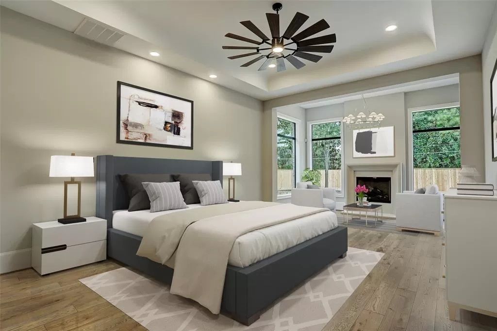 A bedroom with a large bed and a ceiling fan.