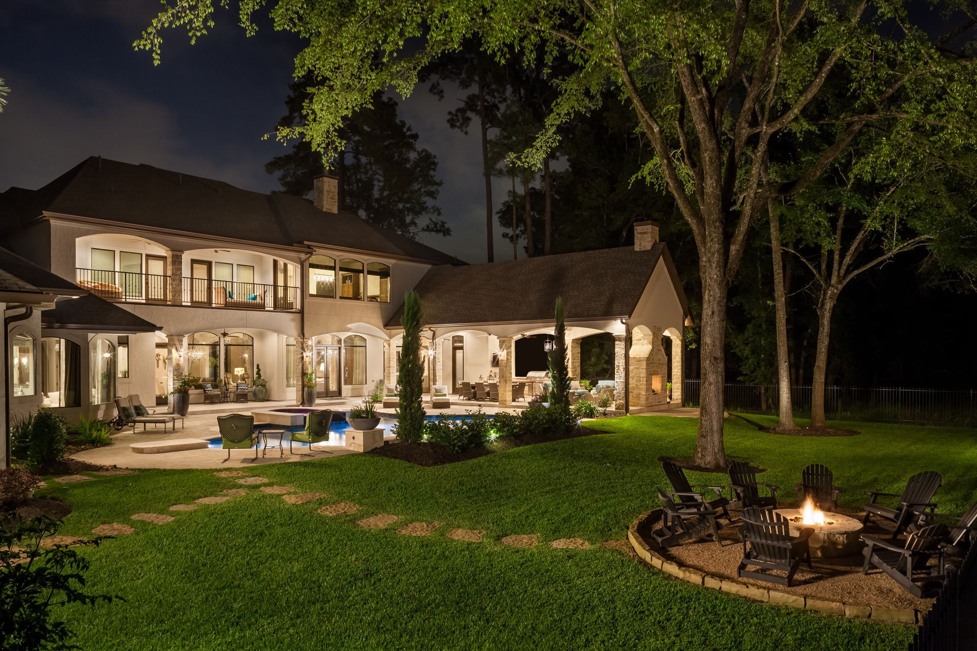 A large house with a fire pit in front of it at night