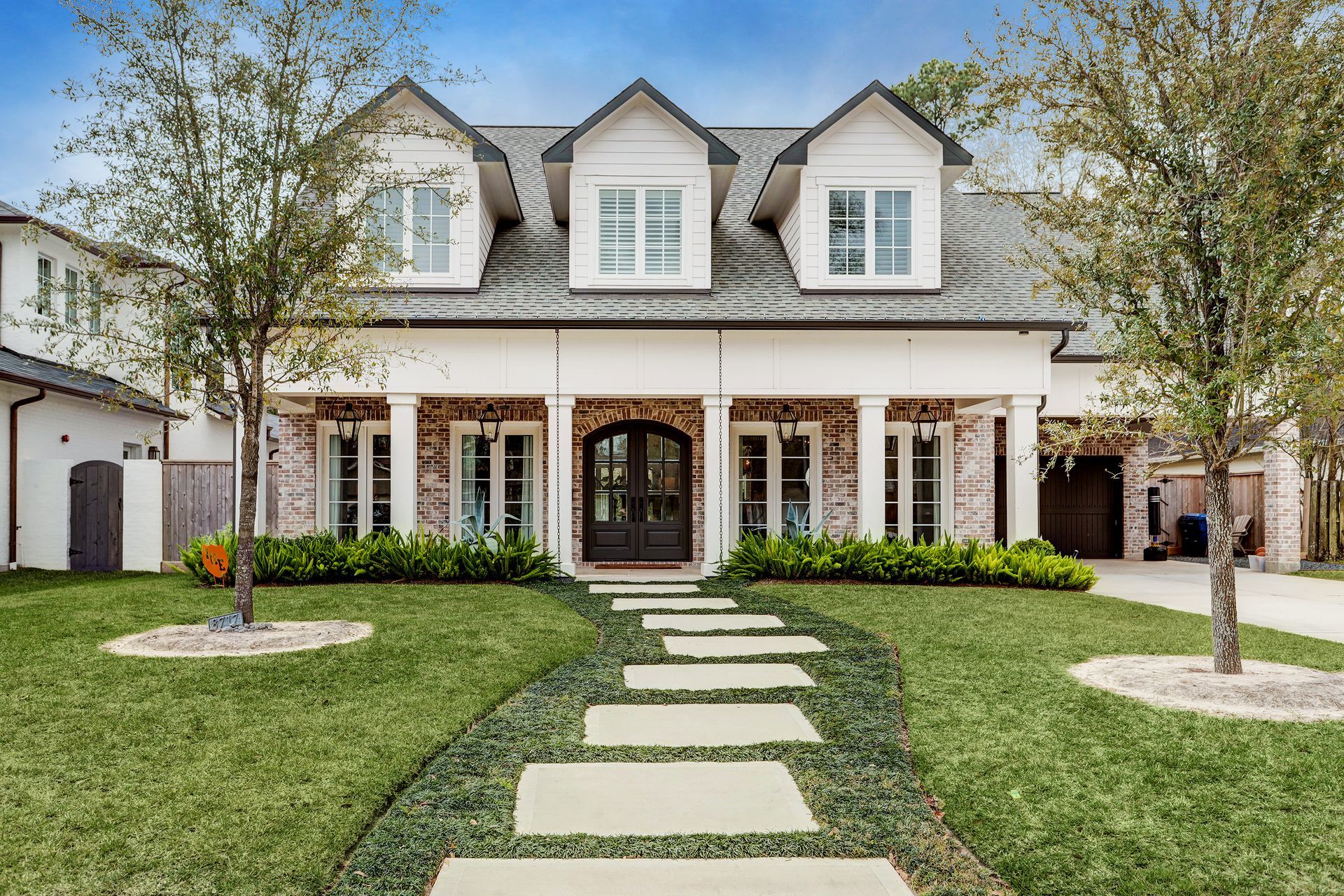 A large white house with a stone walkway leading to it.
