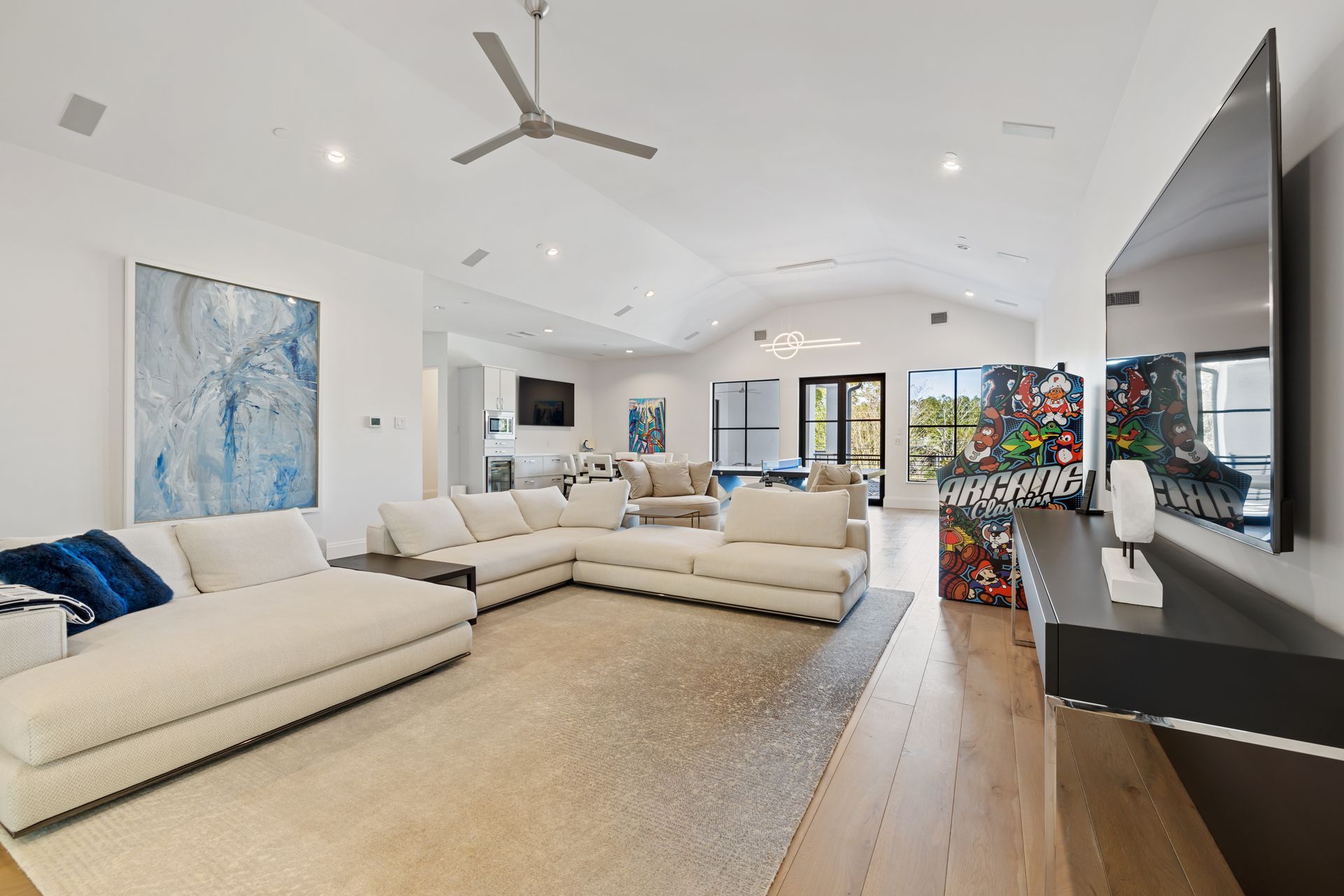 A living room with a large sectional couch and a flat screen tv.