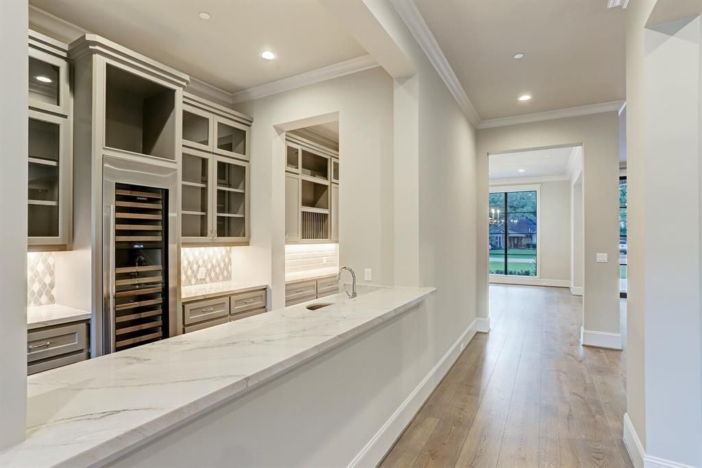 A kitchen with a long counter and a refrigerator.