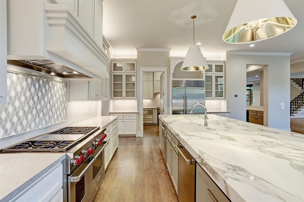 A kitchen with stainless steel appliances and a large island.
