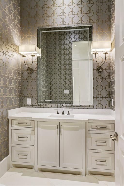 A bathroom with a sink , mirror and drawers.