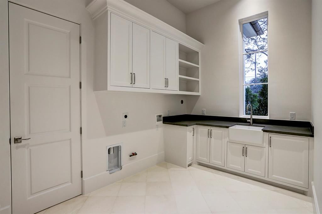 An empty kitchen with white cabinets and black counter tops