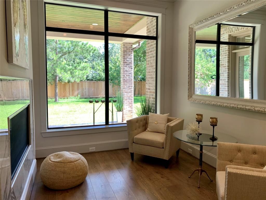 A living room with two chairs , a table , and a fireplace.