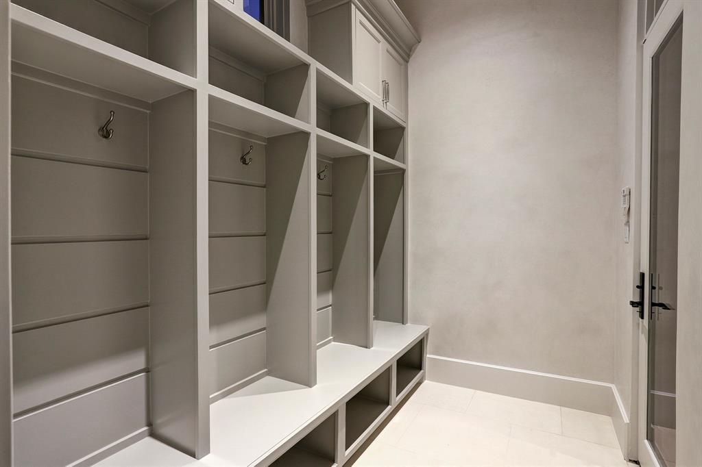 A closet with lots of shelves and hooks on the wall.