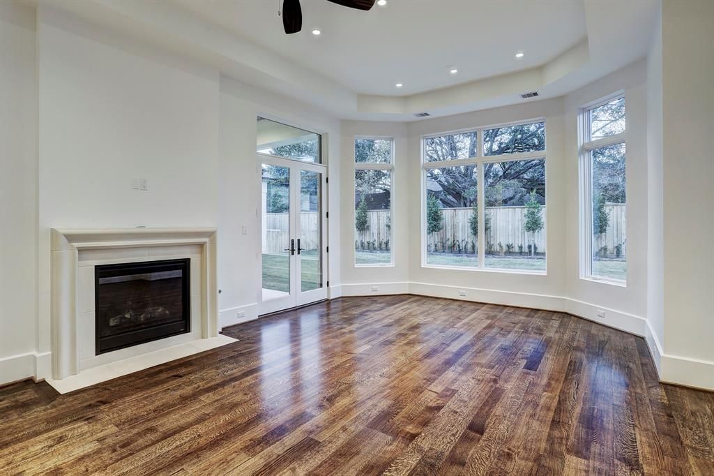 An empty living room with hardwood floors and a fireplace