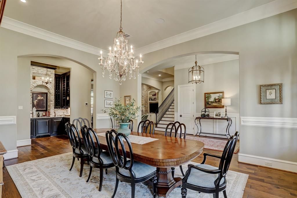 A dining room with a large table and chairs and a chandelier.