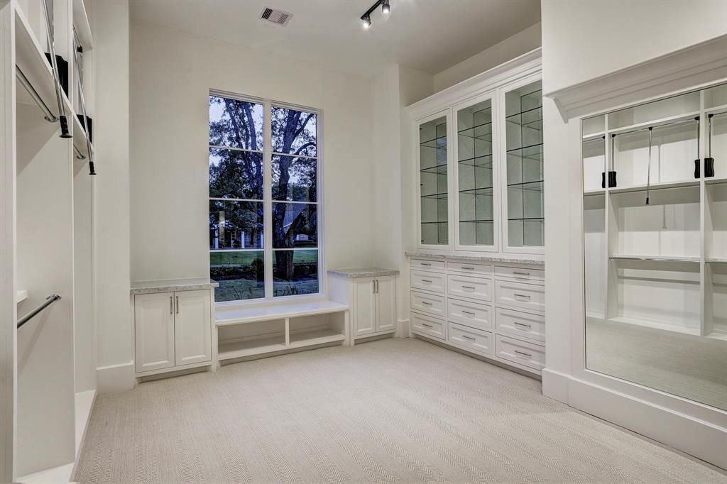 A large closet with lots of shelves and a window.