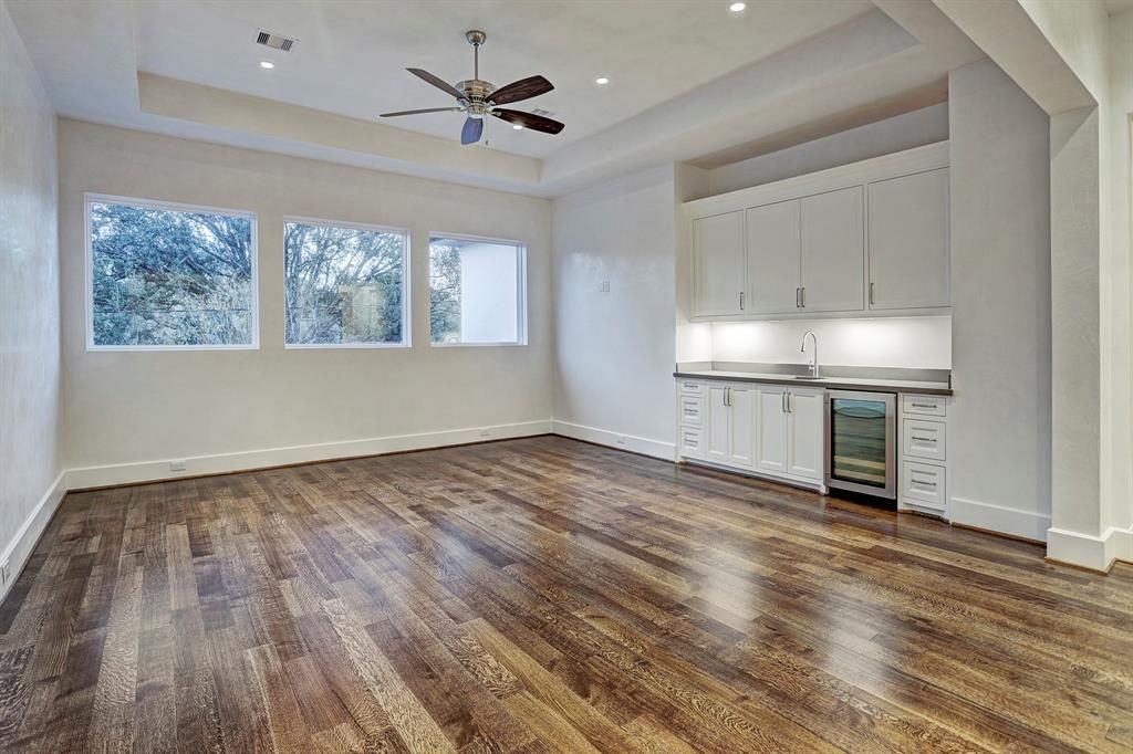 An empty room with hardwood floors and a ceiling fan
