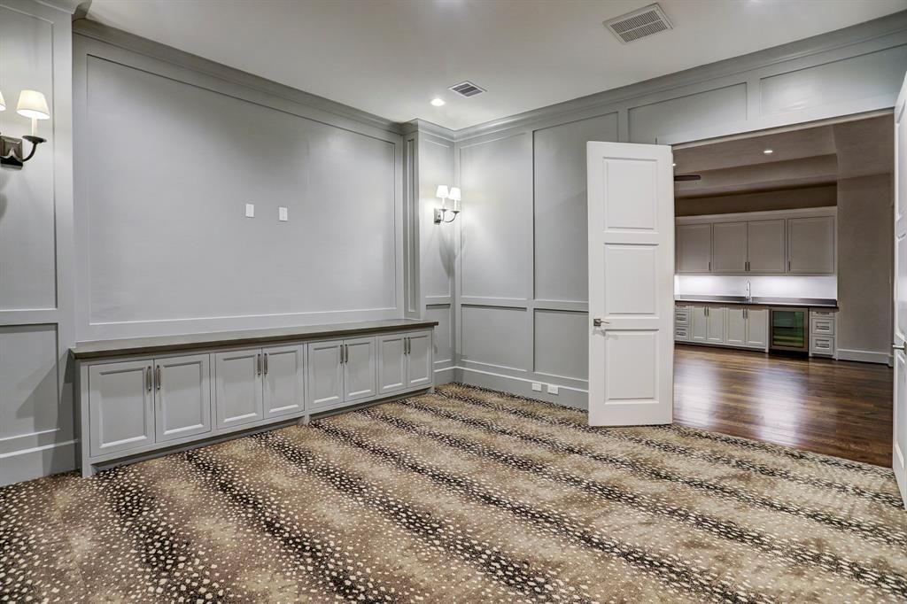 An empty room with a striped carpet and a door open.