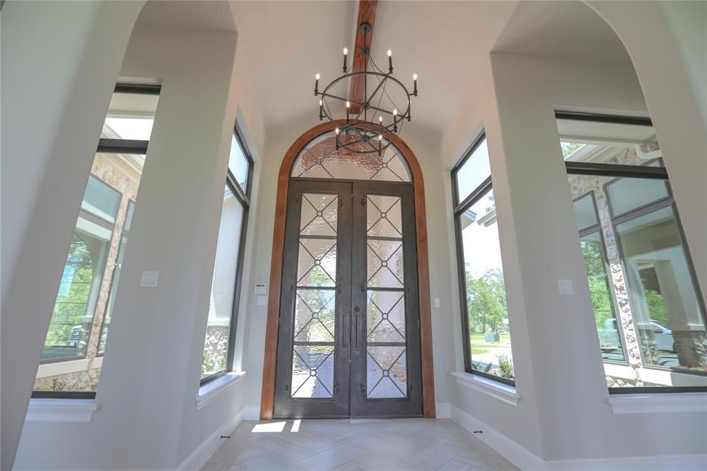 A hallway in a house with a chandelier hanging from the ceiling.