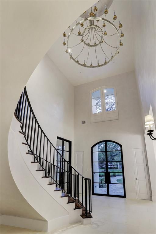 A spiral staircase with a chandelier hanging from the ceiling