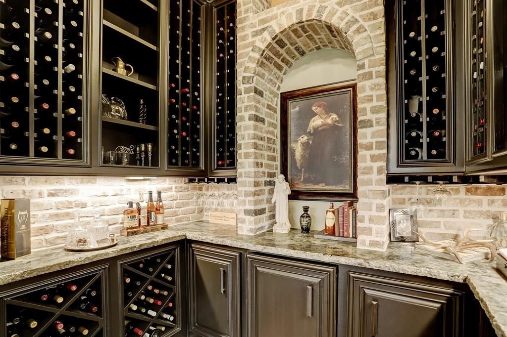 A kitchen with a wine cellar and a painting on the wall.