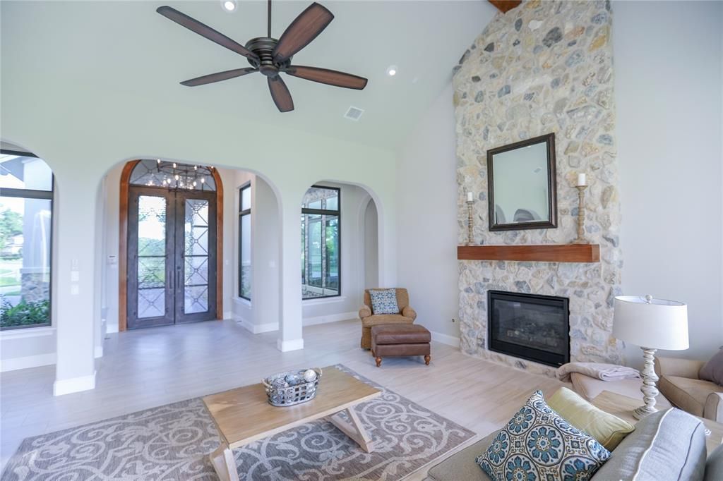 A living room with a fireplace and a ceiling fan.