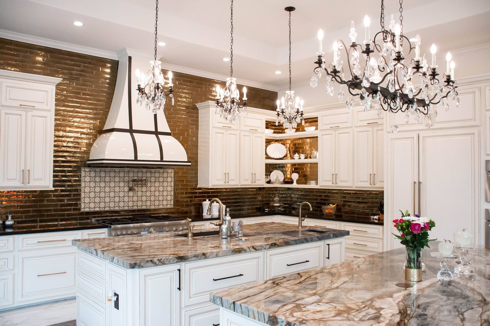 A kitchen with white cabinets , granite counter tops , and a chandelier hanging from the ceiling.