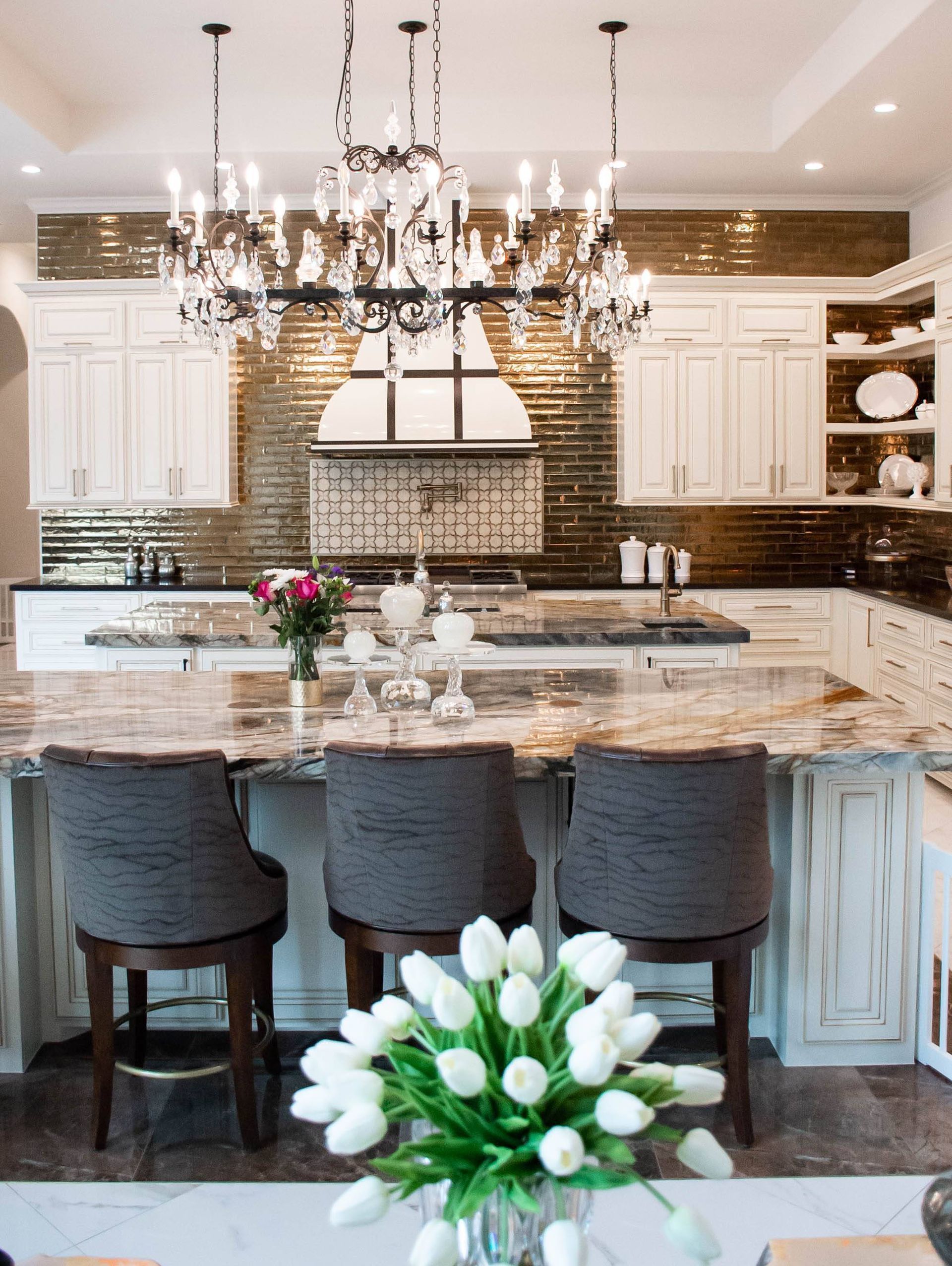 A kitchen with a large island and a chandelier hanging from the ceiling