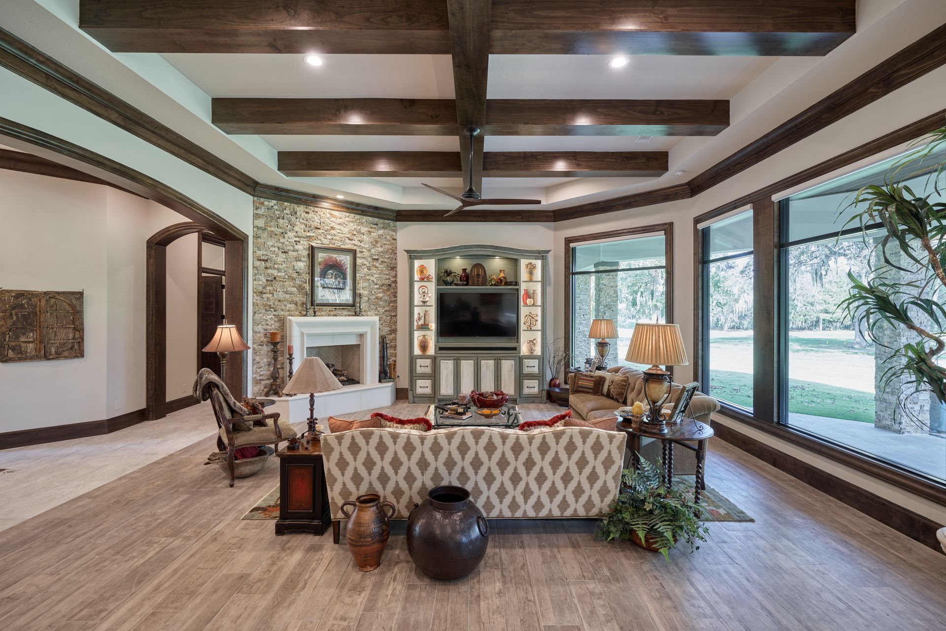 A living room with a couch , chairs , lamps and a fireplace.