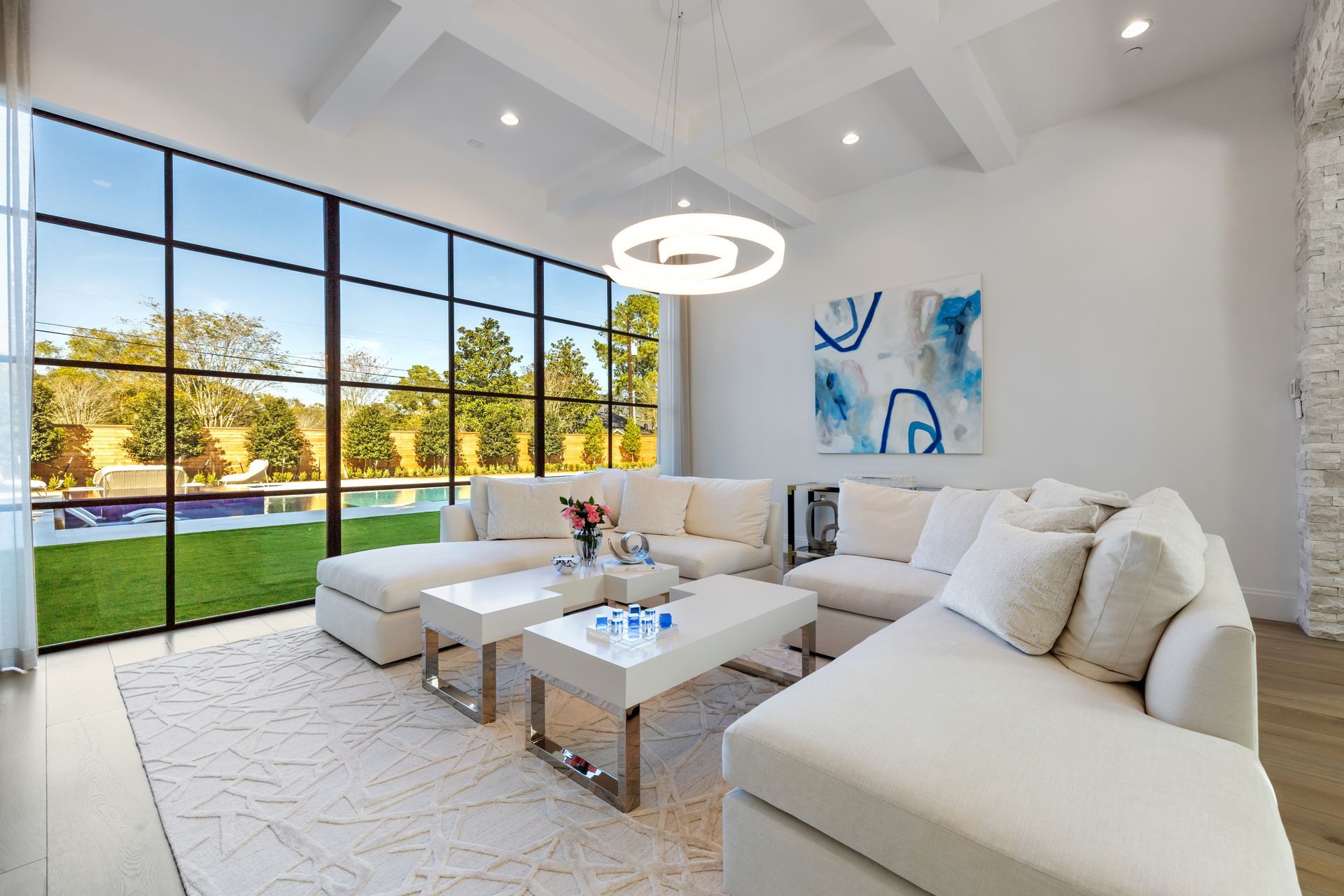 A living room with white furniture and a large window.