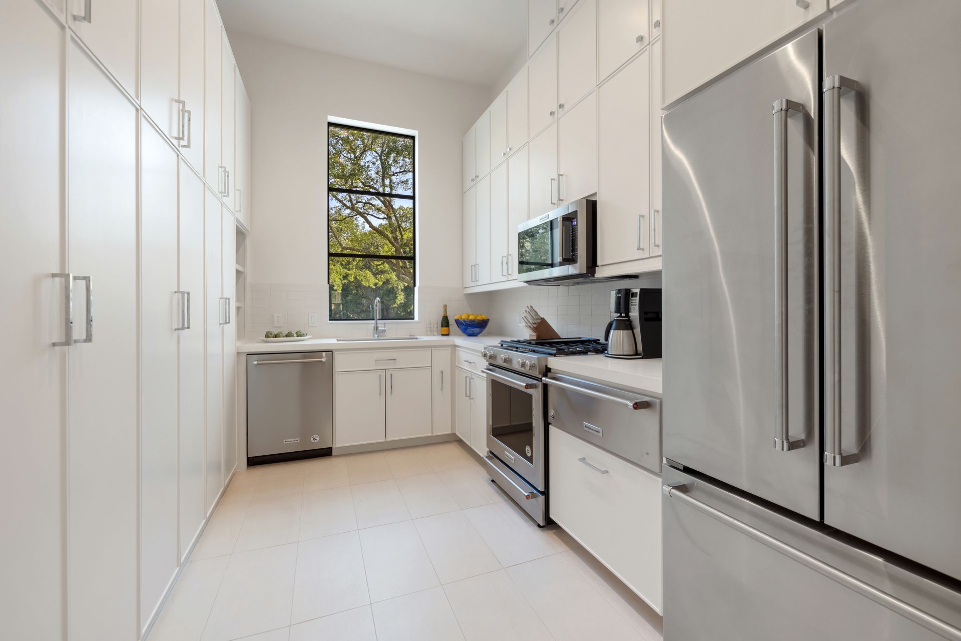 A kitchen with stainless steel appliances and white cabinets.