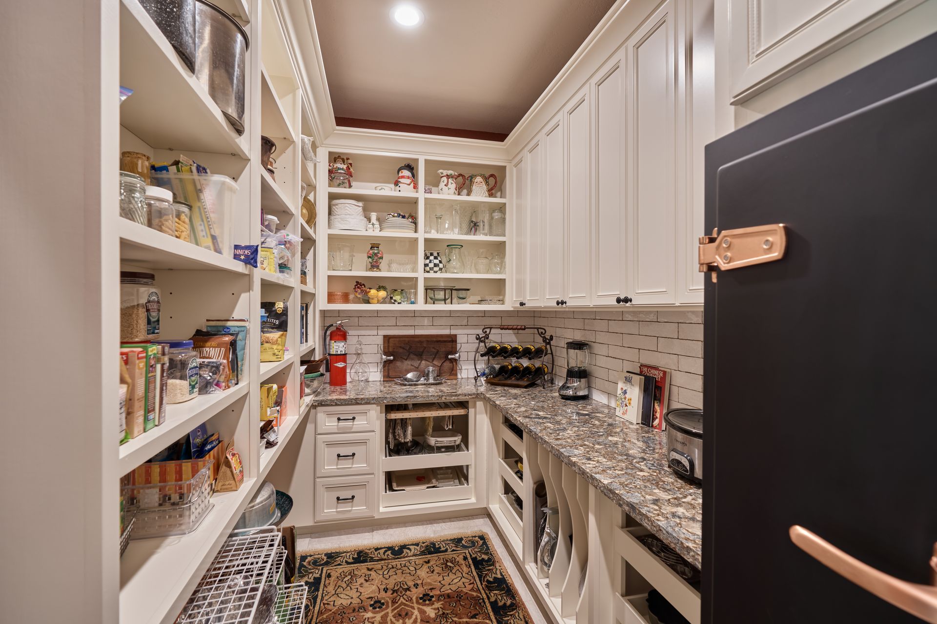 A kitchen with a pantry filled with lots of food and appliances.