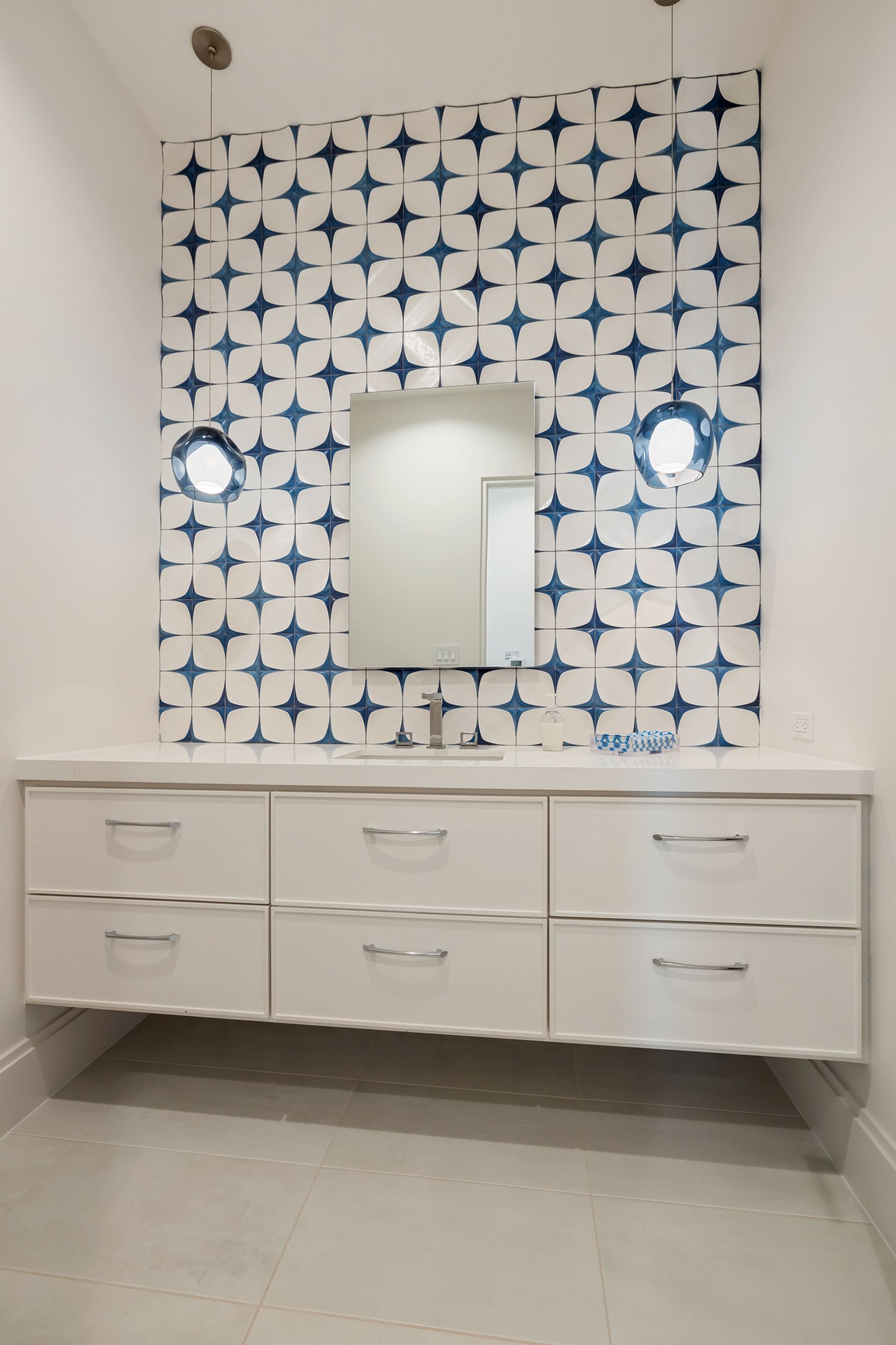 A bathroom with blue and white tiles and a sink