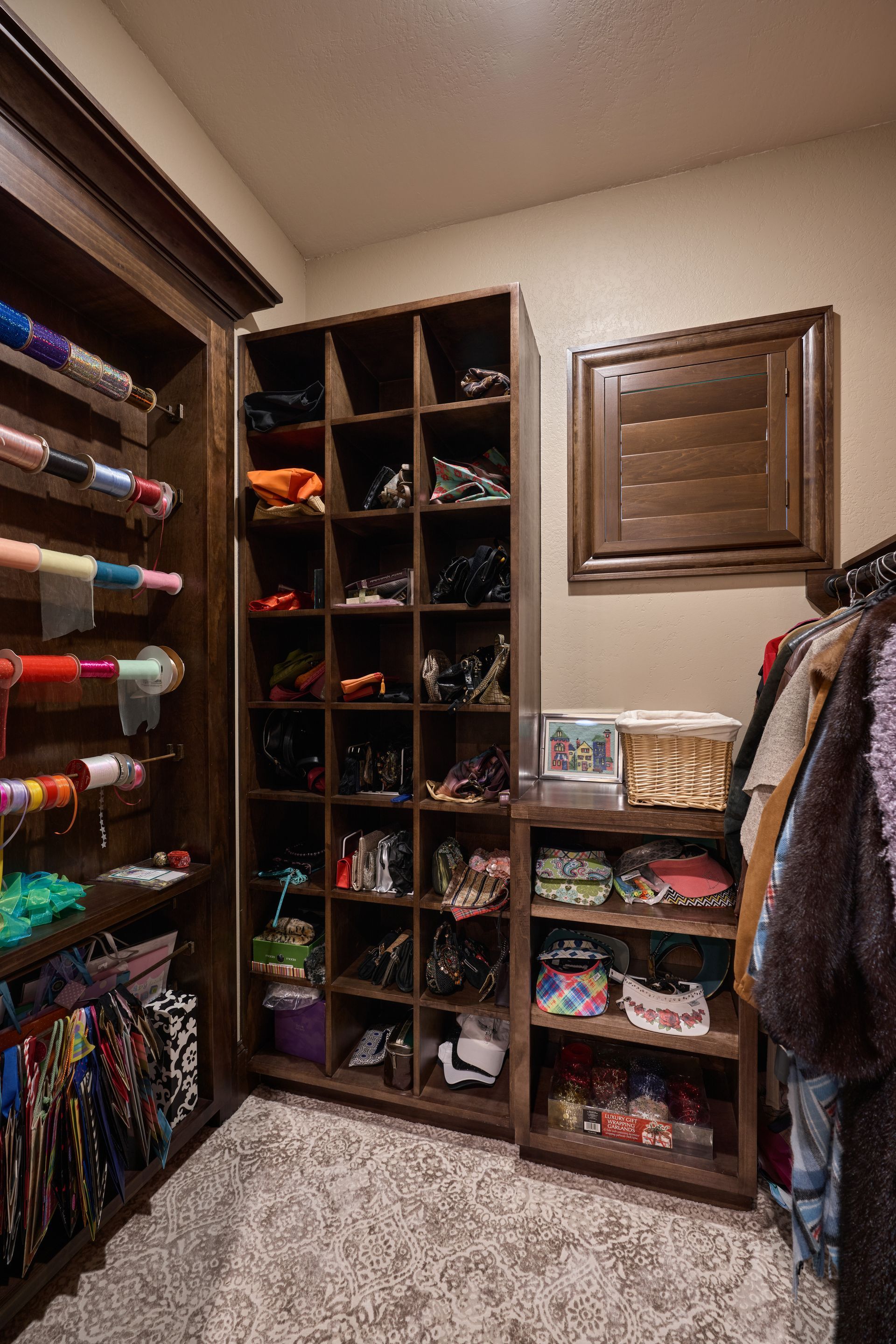 A walk in closet filled with lots of clothes and shoes.