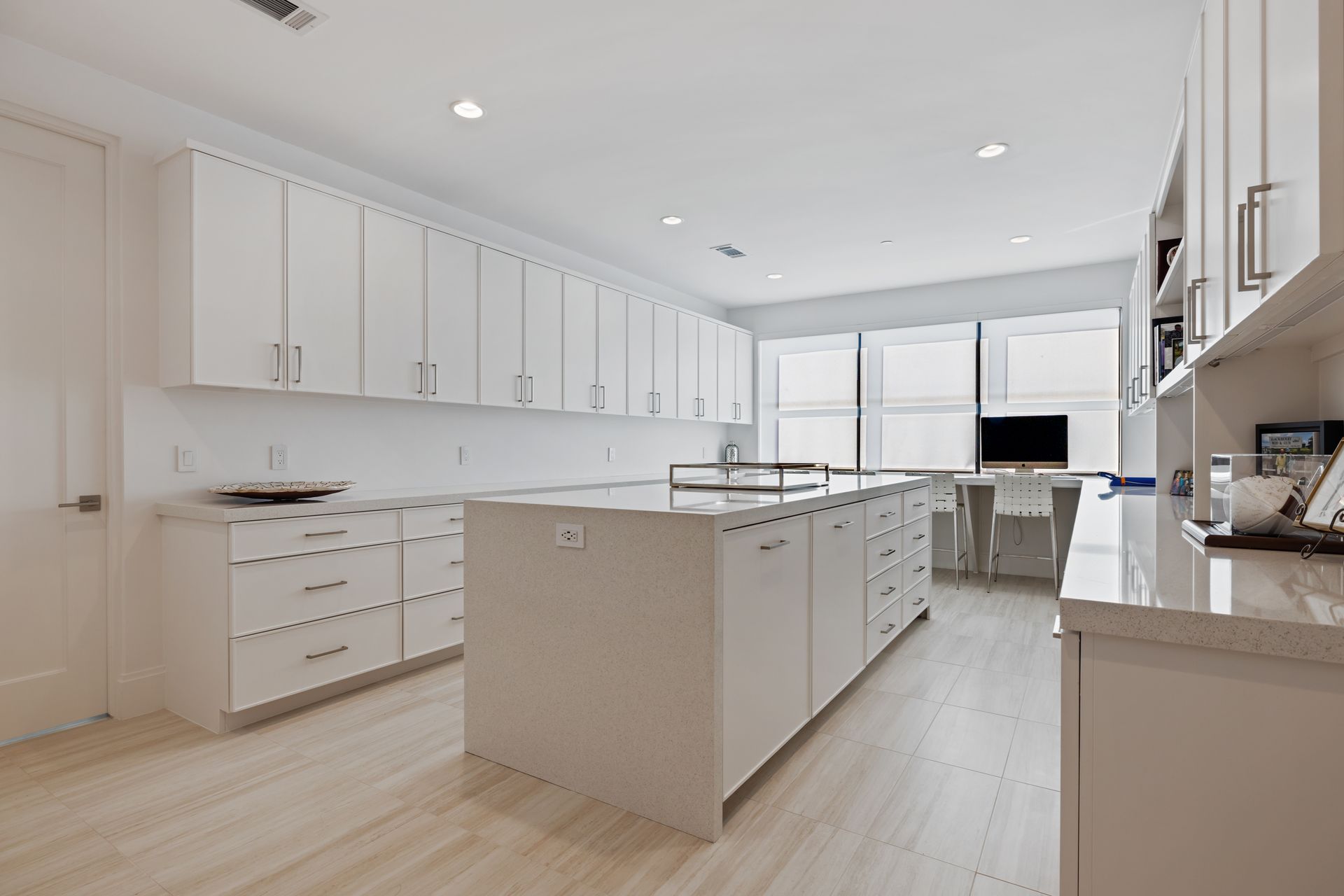 A kitchen with white cabinets and a large island