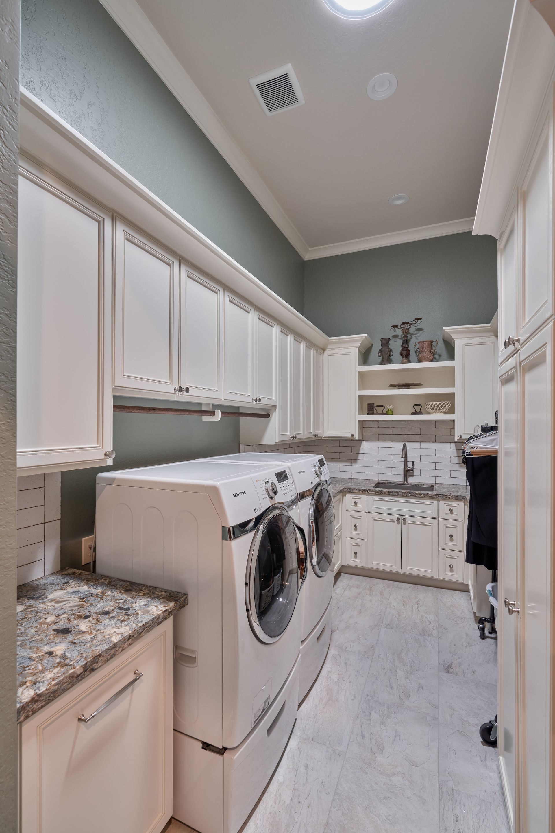 A laundry room with a washer and dryer and a sink.