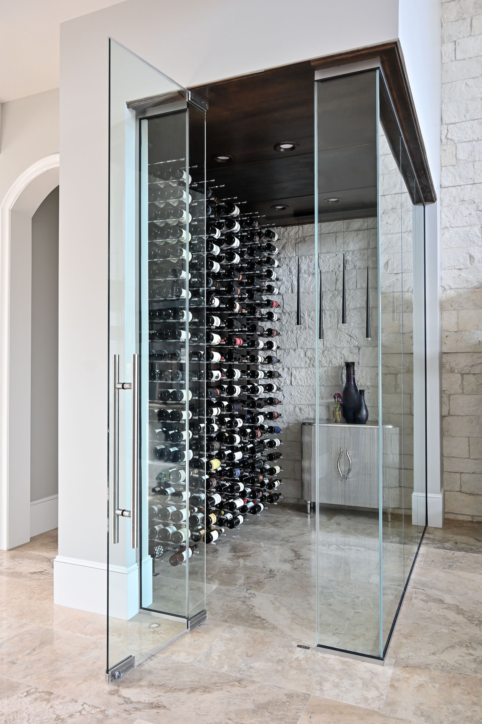 A wine cellar with a glass door and lots of wine bottles