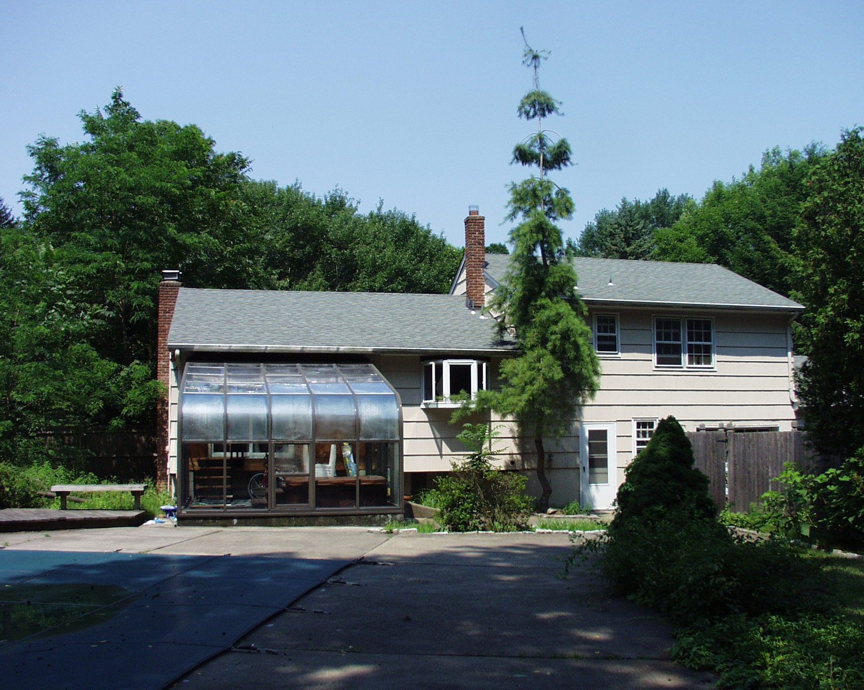 A woman in a green shirt is laughing with her mouth open