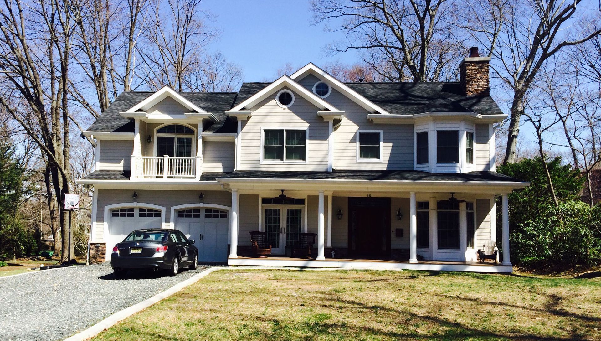 A blue house with a white garage door is for sale.