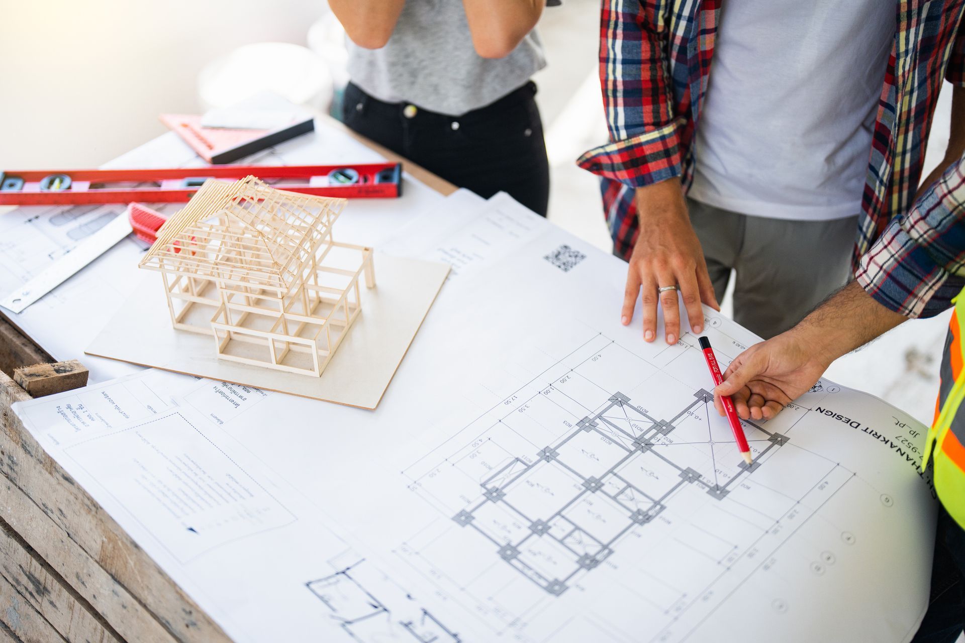 A man and a woman are looking at a blueprint of a building.