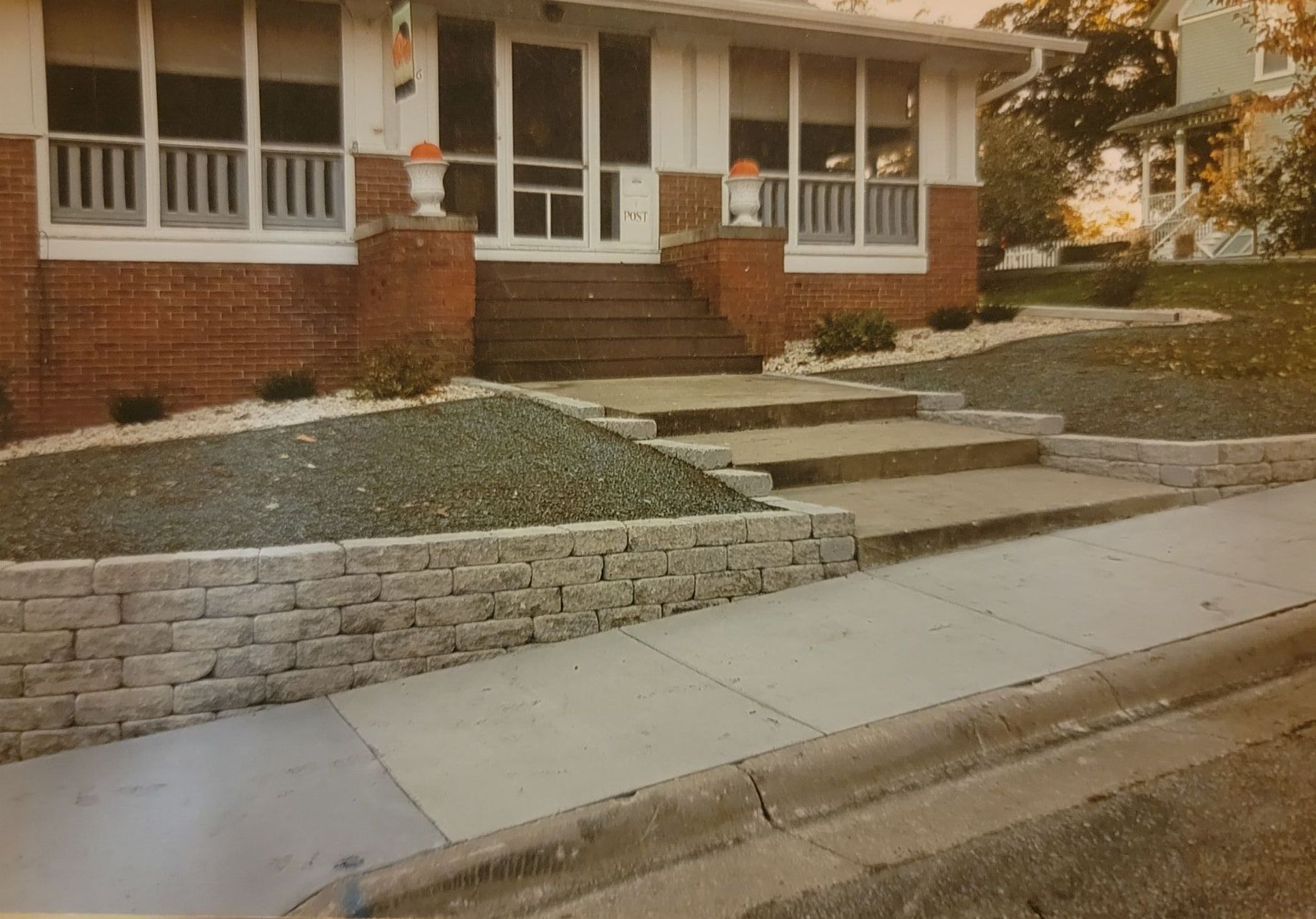 A brick house with retaining wall and steps leading up to the front door