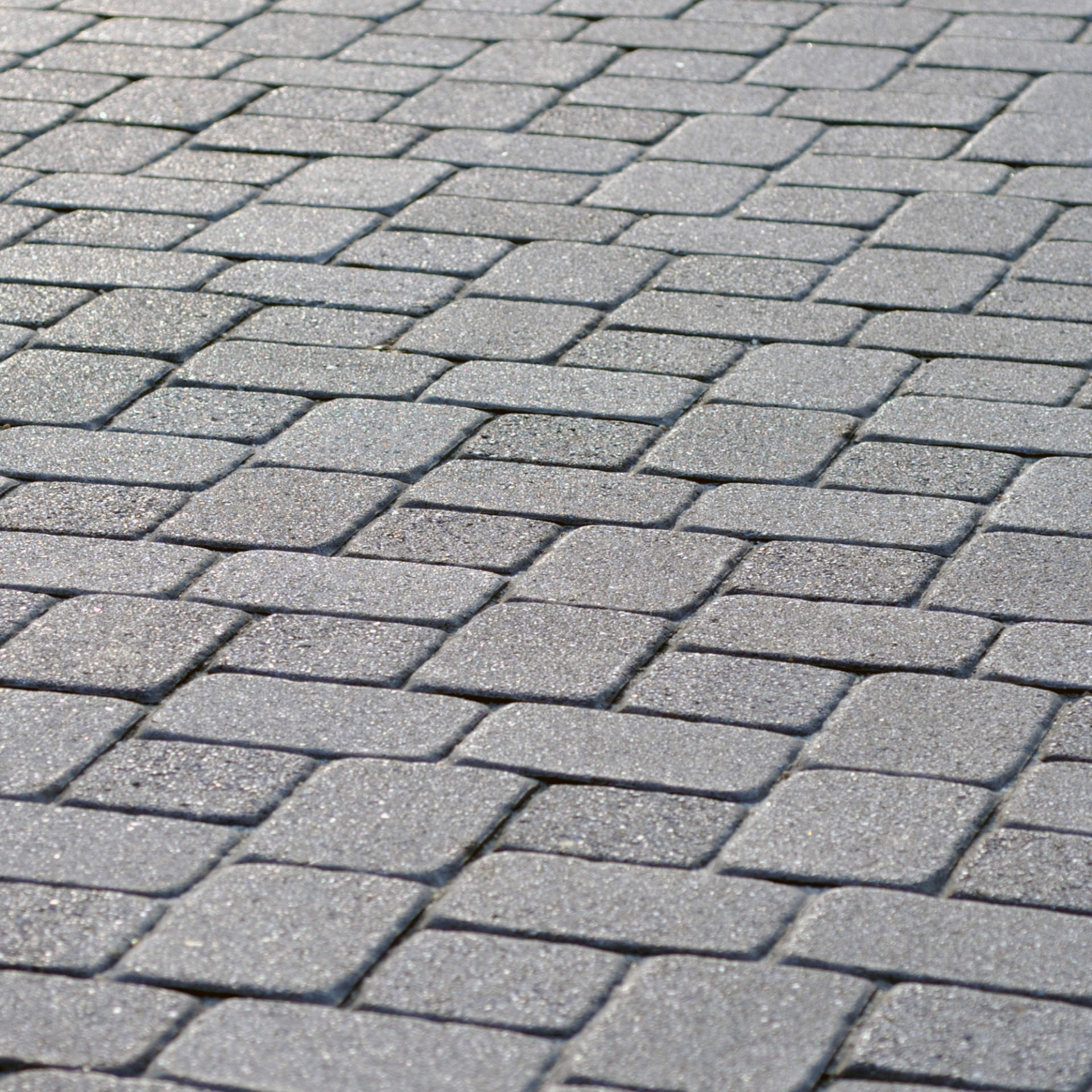 A close up of a brick walkway with a diagonal pattern