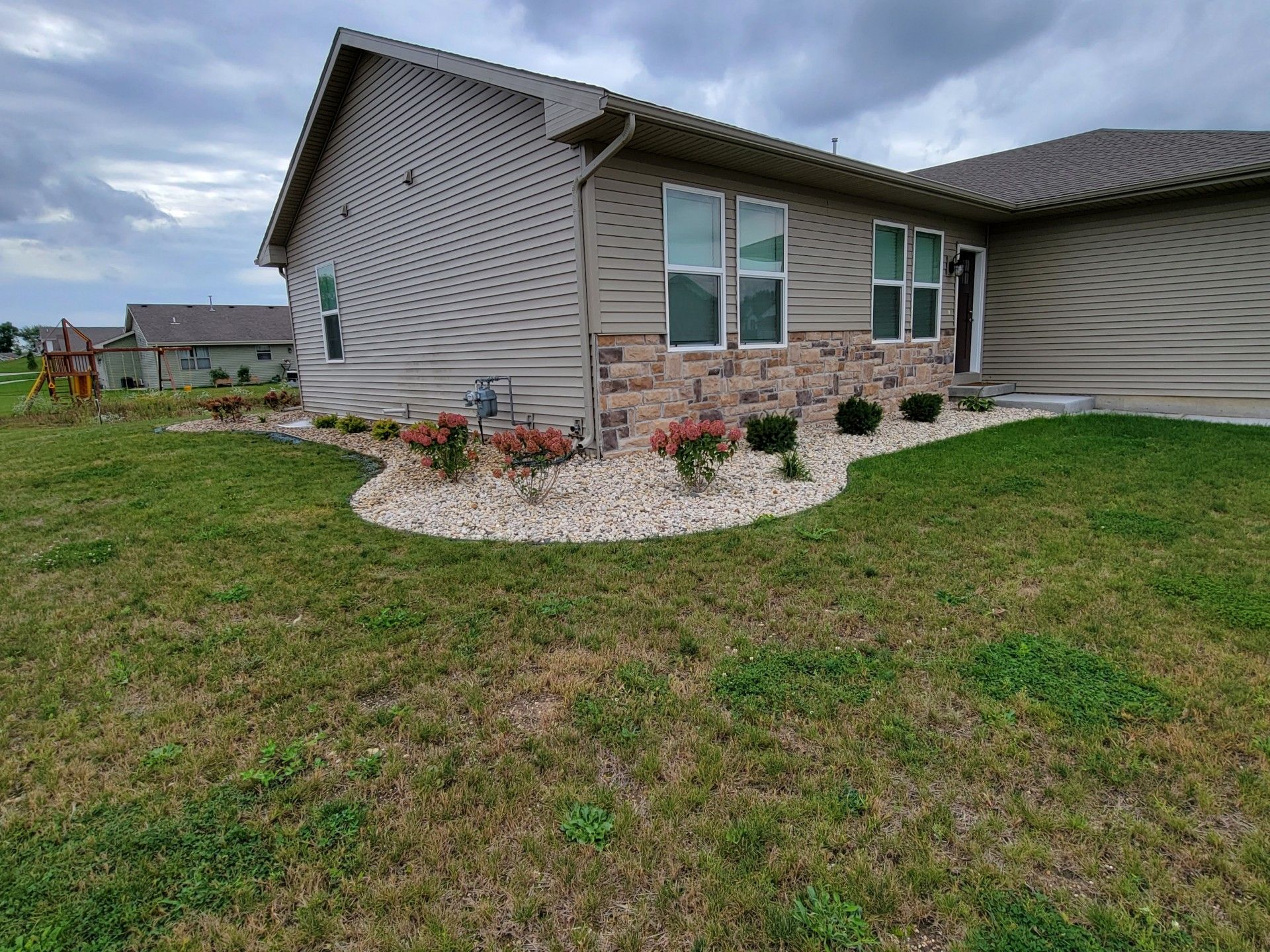 A house with a lush green lawn in front of it.