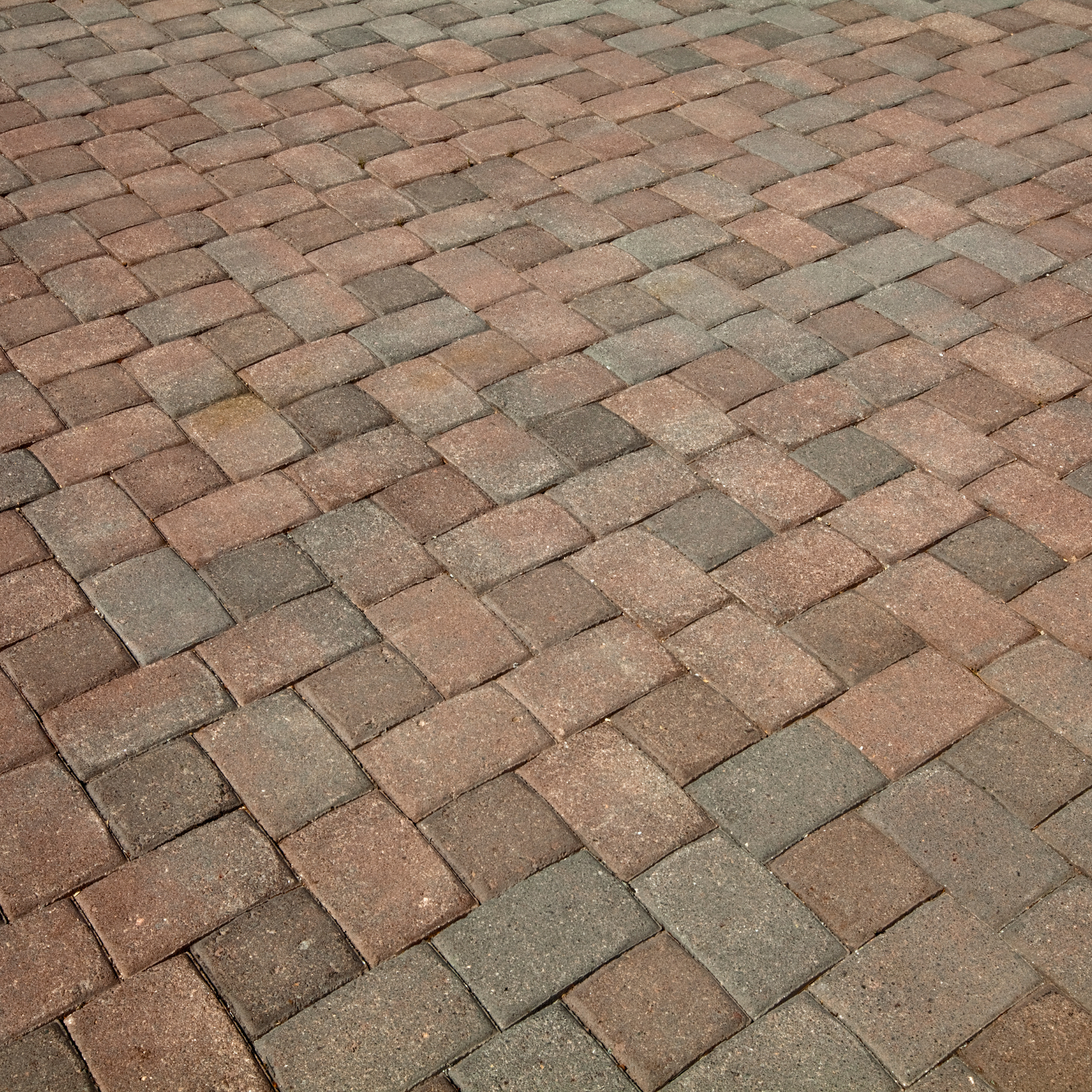 A close up of a brick paver patio with a diagonal pattern