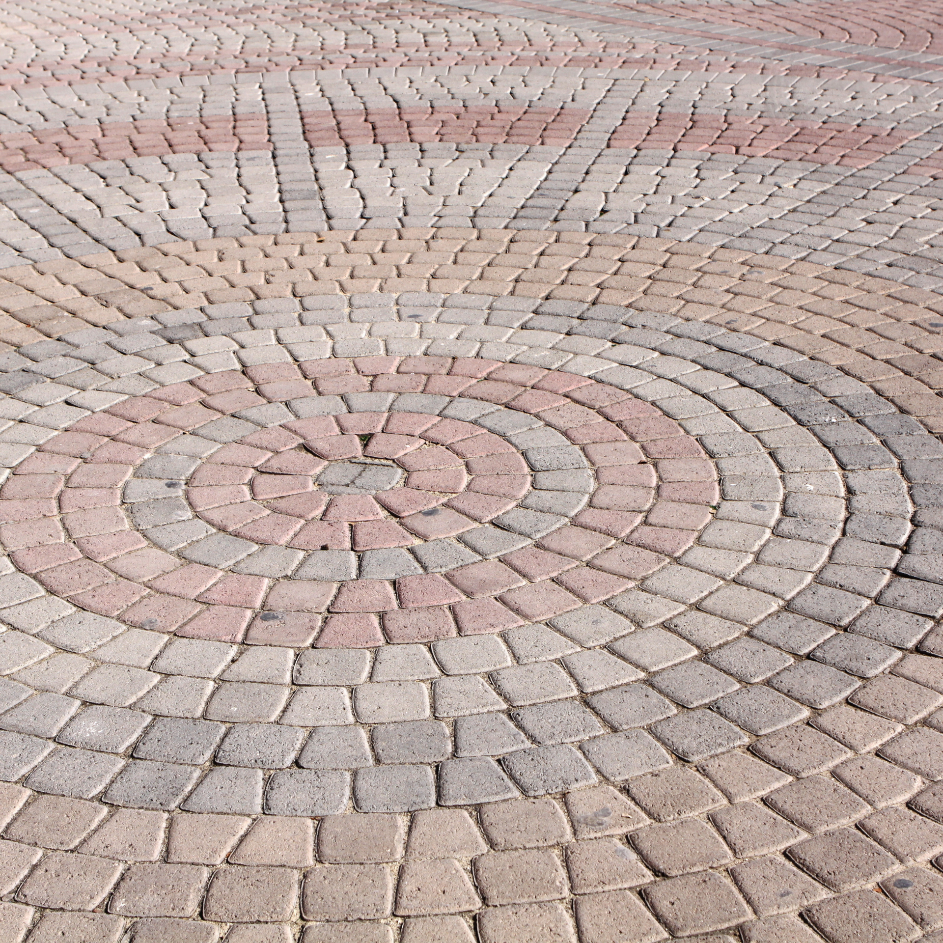 A circular pattern of bricks on a patio