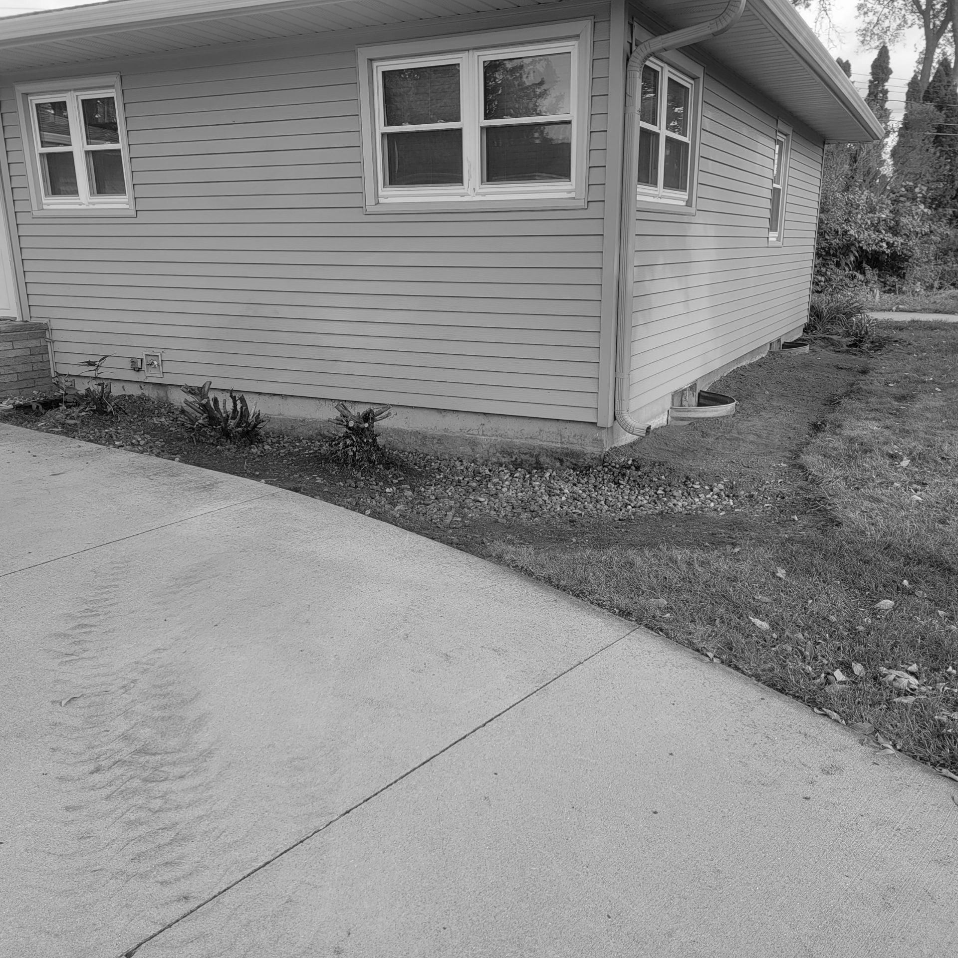 A black and white photo of a house with water drainage problems