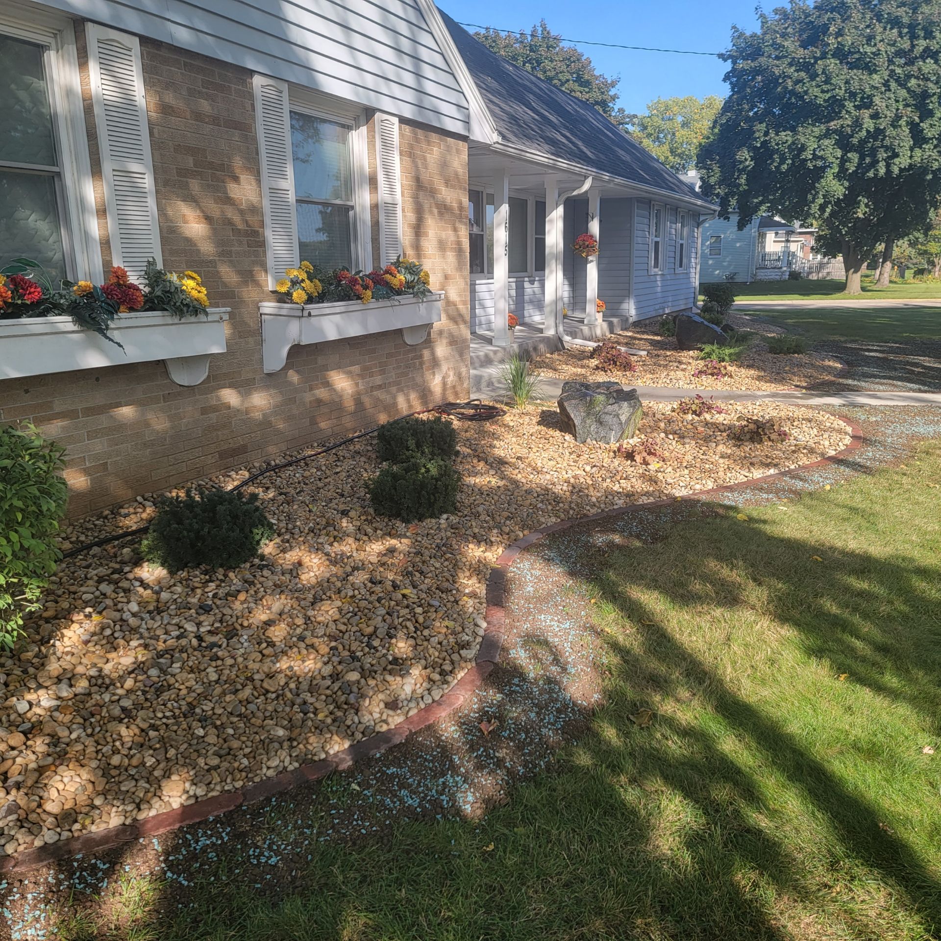 A brick house with a lush green lawn in front of it.