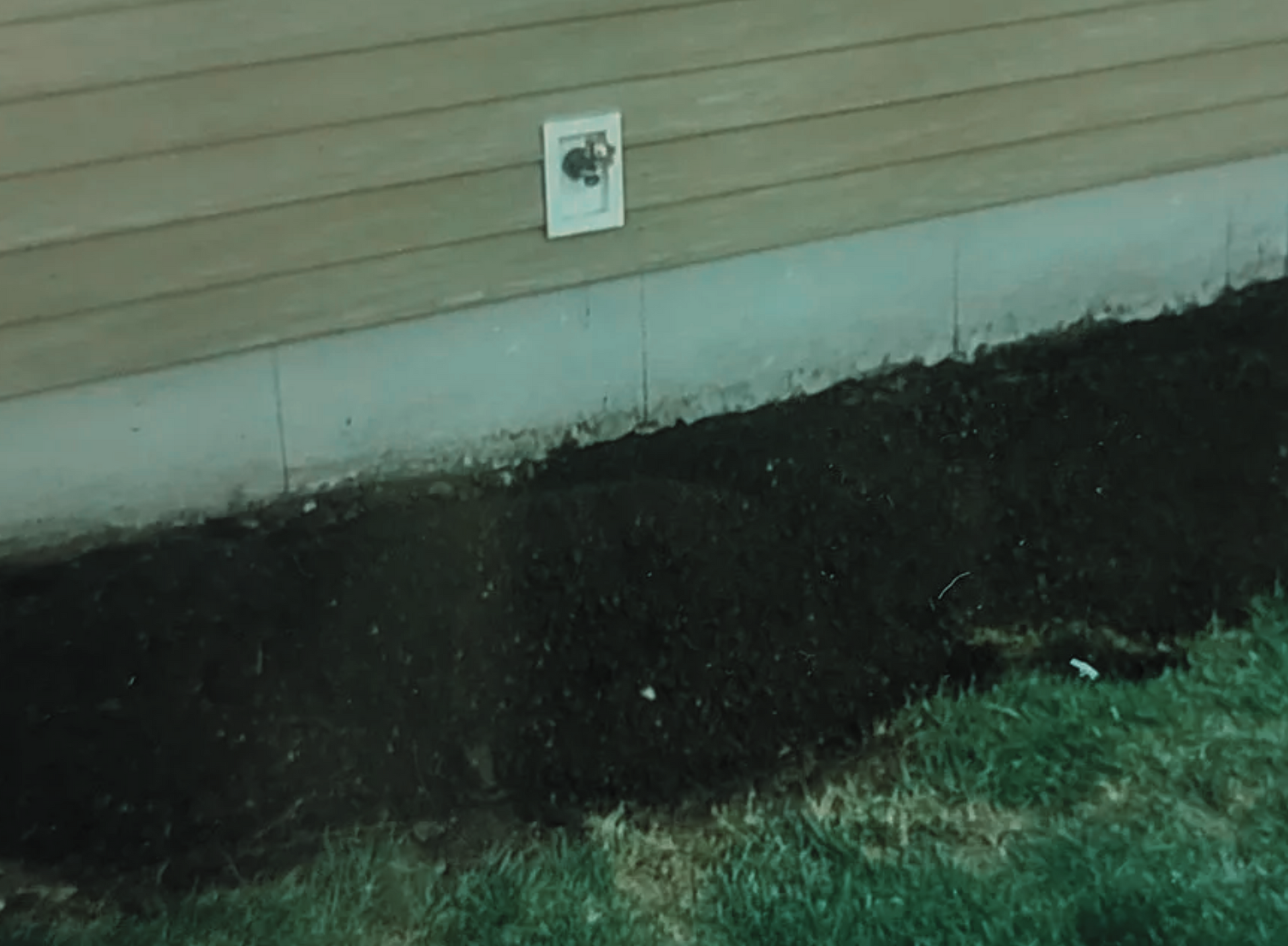 A house with a drain on the side of it.