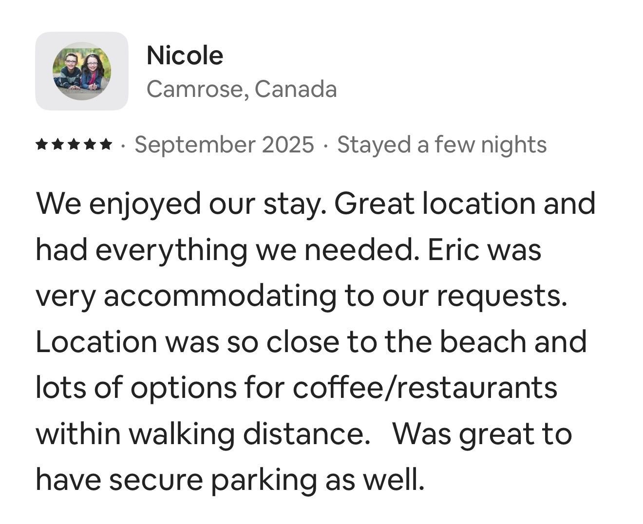 A five-star review from Nicole in Camrose, Canada, praising the location, amenities, parking, and host, Eric.