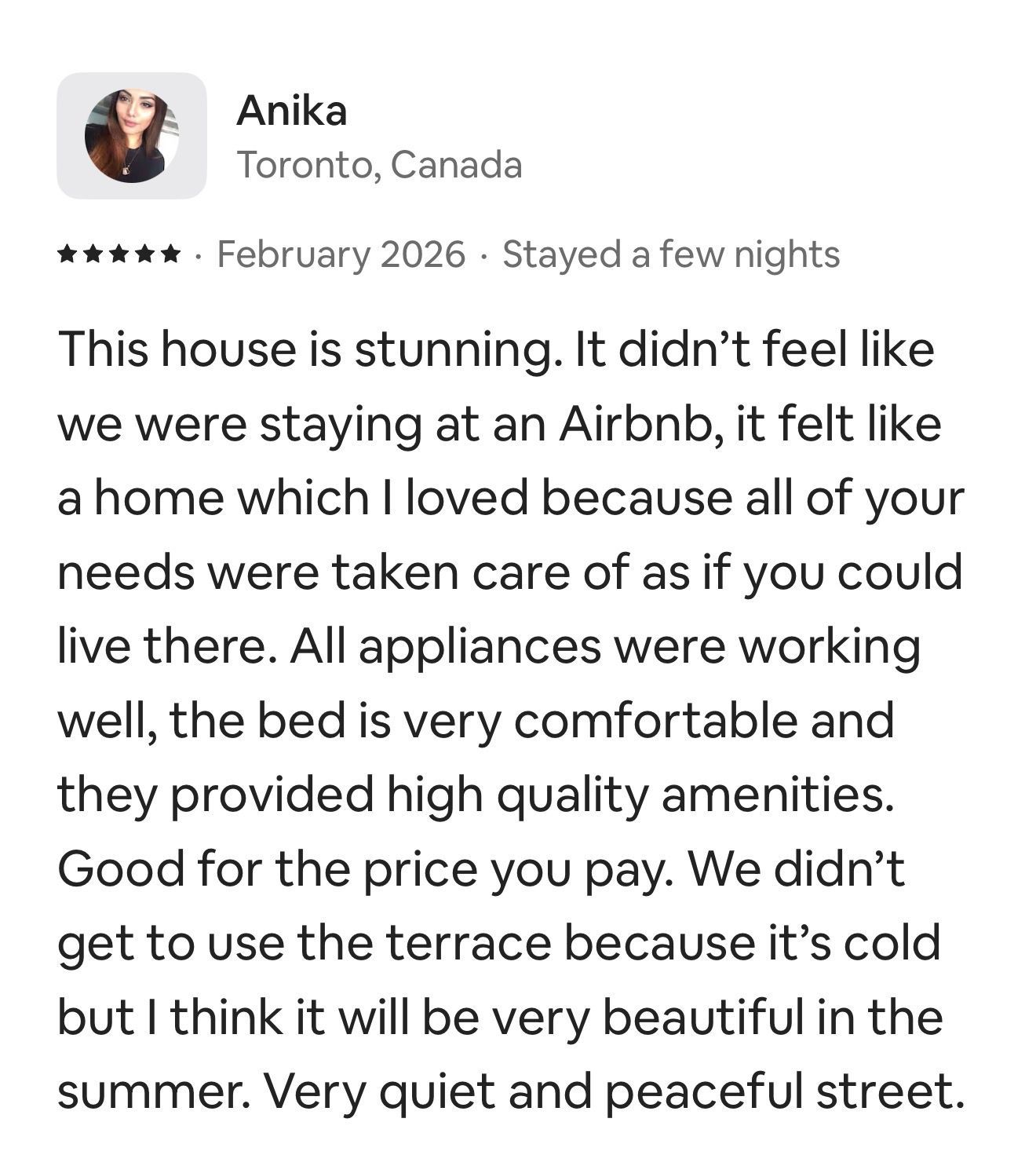 An Airbnb review from a guest named Anika, rating the house five stars for comfort, amenities, and a peaceful location.