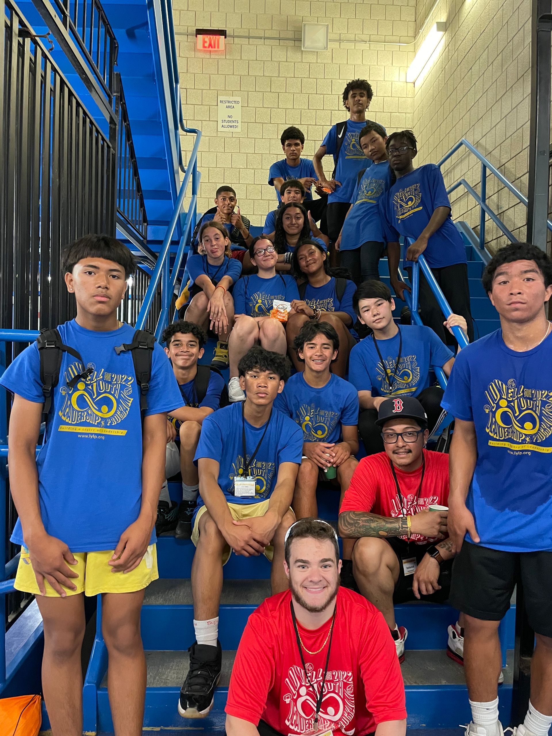 A group of young people are posing for a picture on the stairs.