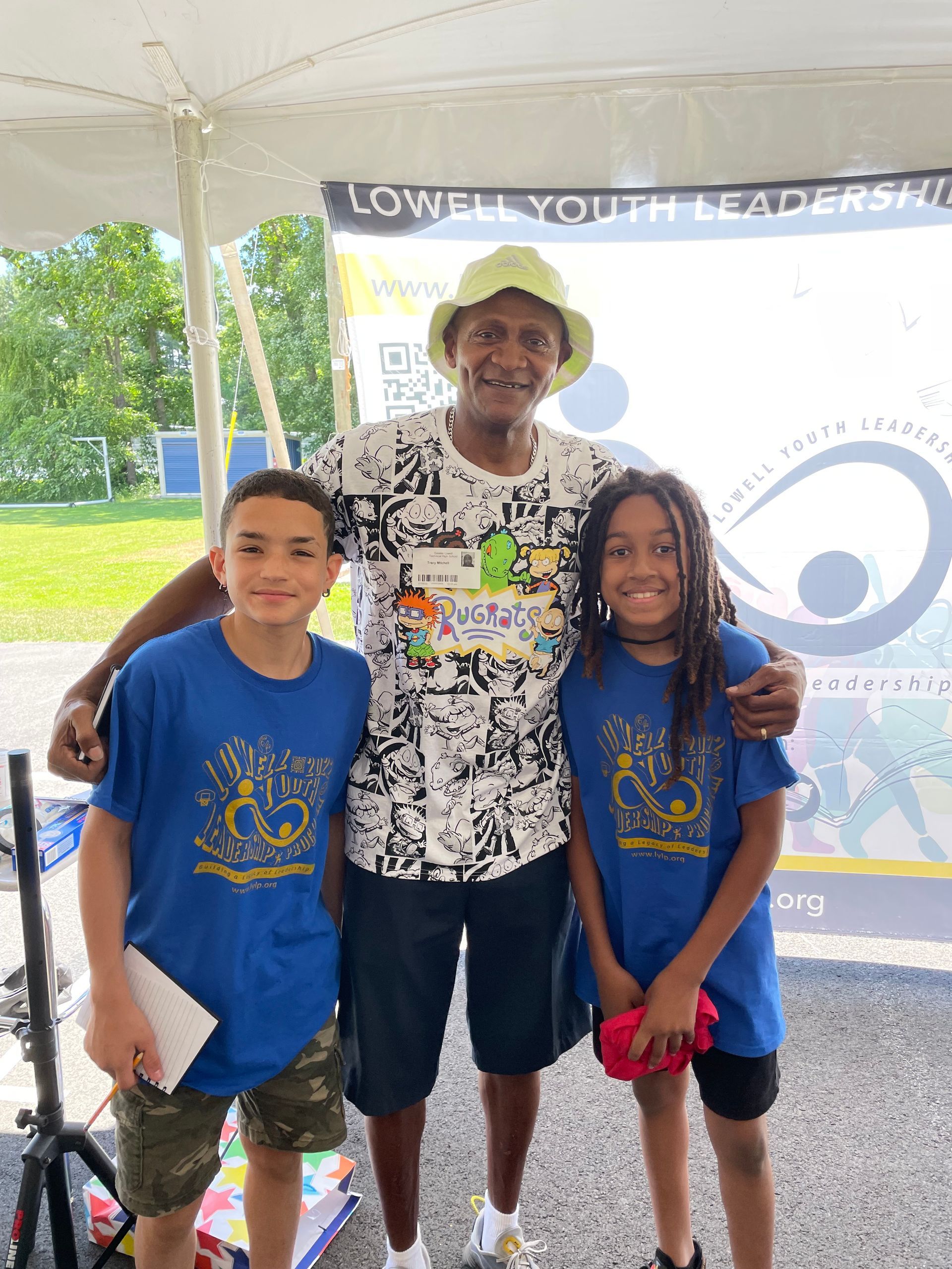 A man and two children are posing for a picture under a tent.