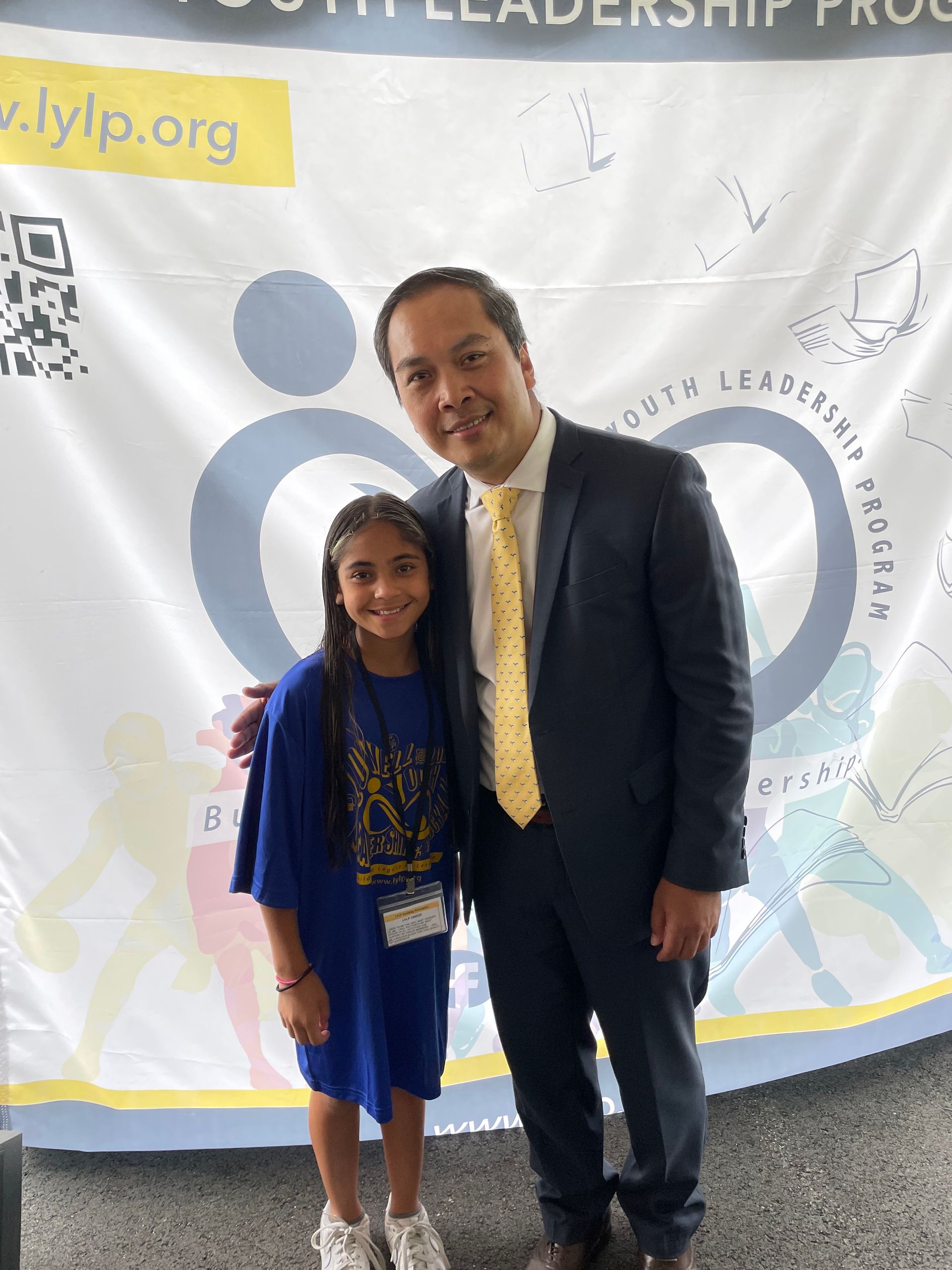 A man in a suit and tie is posing for a picture with a little girl.