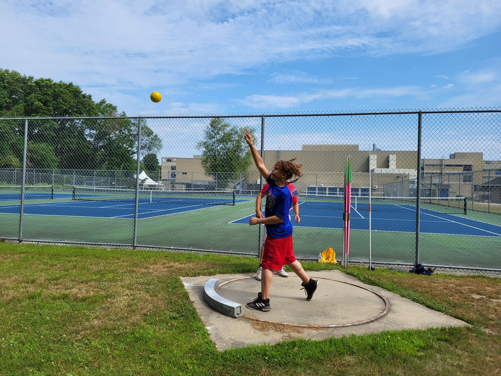 A young boy is throwing a ball in a park.