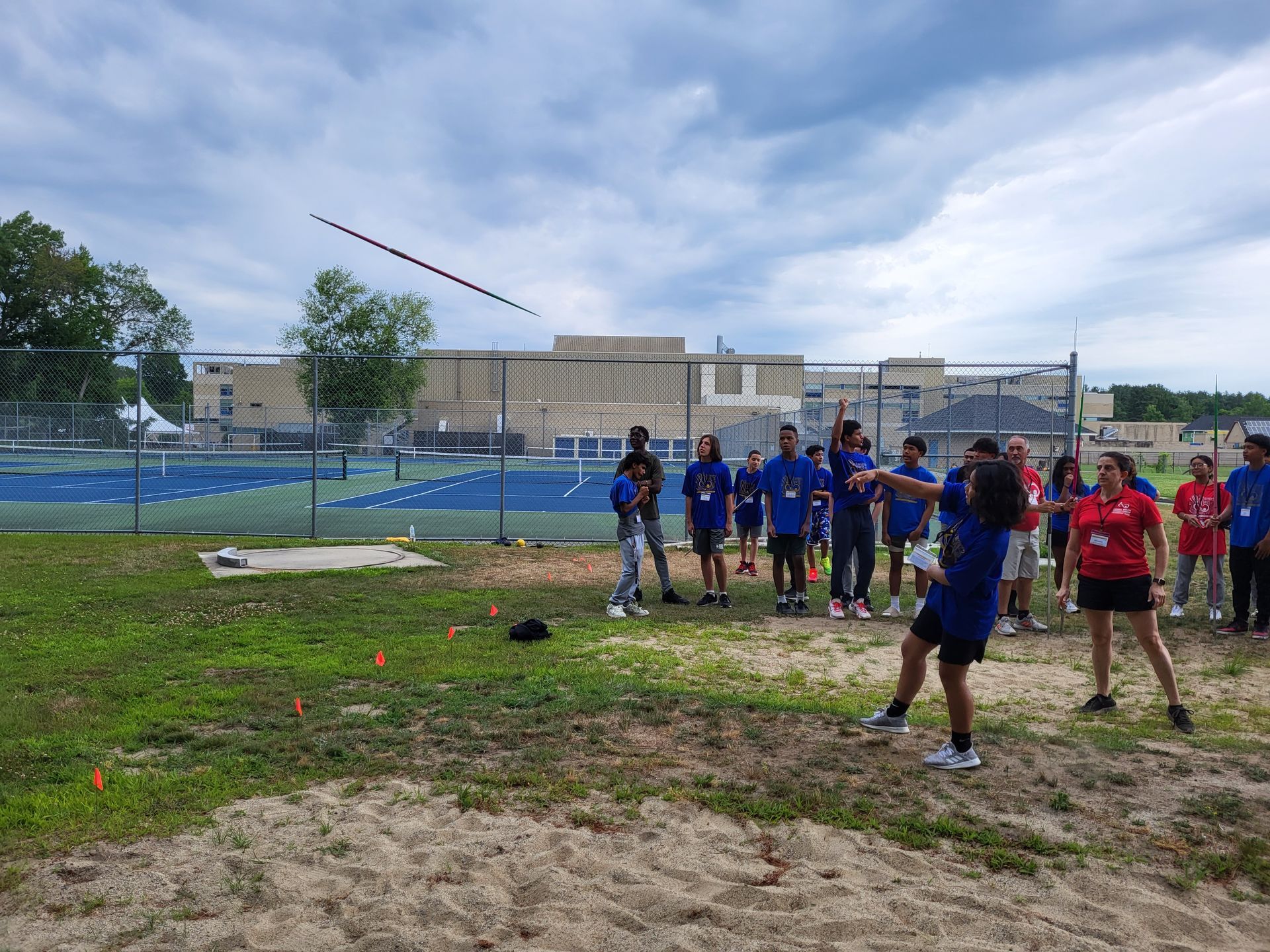 A group of people are standing in a field throwing a frisbee.