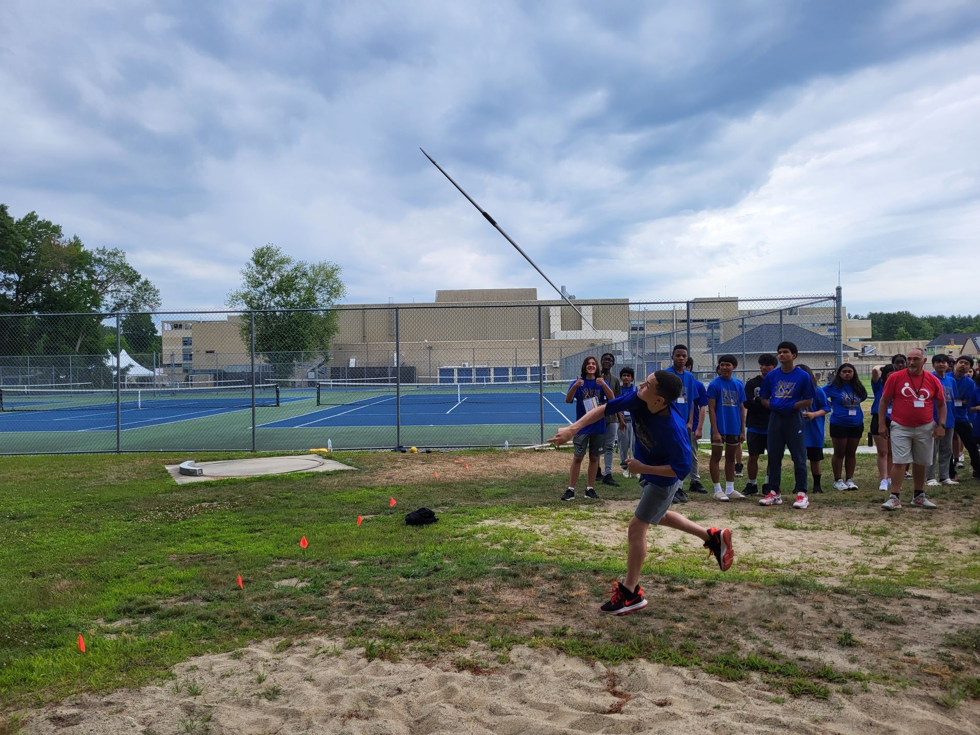 A young boy is throwing a javelin in a field.