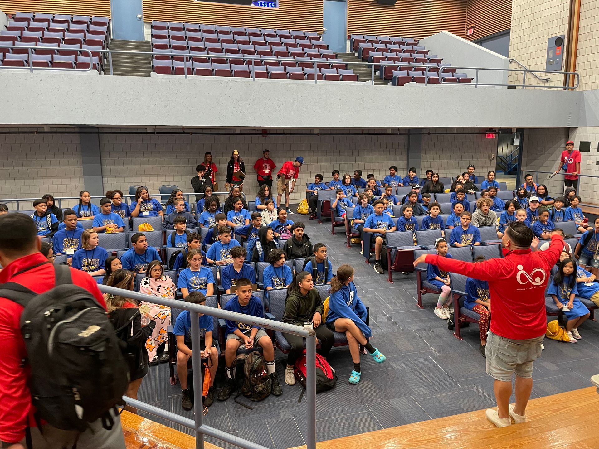 A large group of people are sitting in a large auditorium.